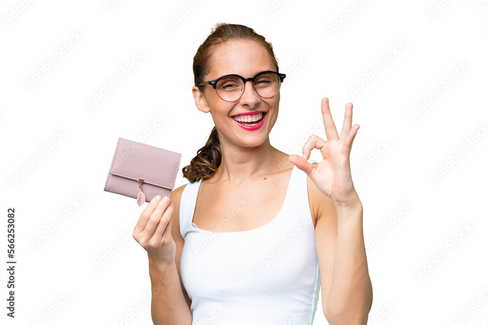 Young caucasian woman holding a wallet over isolated background showing ok sign with fingers Young caucasian woman holding a wallet over isolated background showing ok sign with fingers
