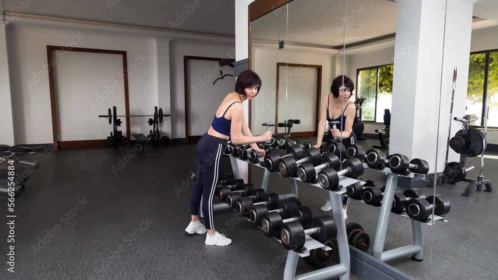 A woman in the gym chooses dumbbells for herself. A woman in the gym chooses dumbbells for herself.
