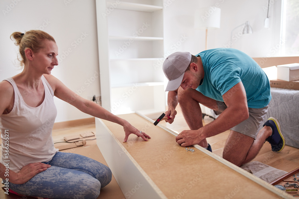 Fototapeta premium Husband and wife assembling new furniture - home renovation concept.
