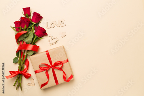 Valentines day gift box with red roses on color background, top view © Liami