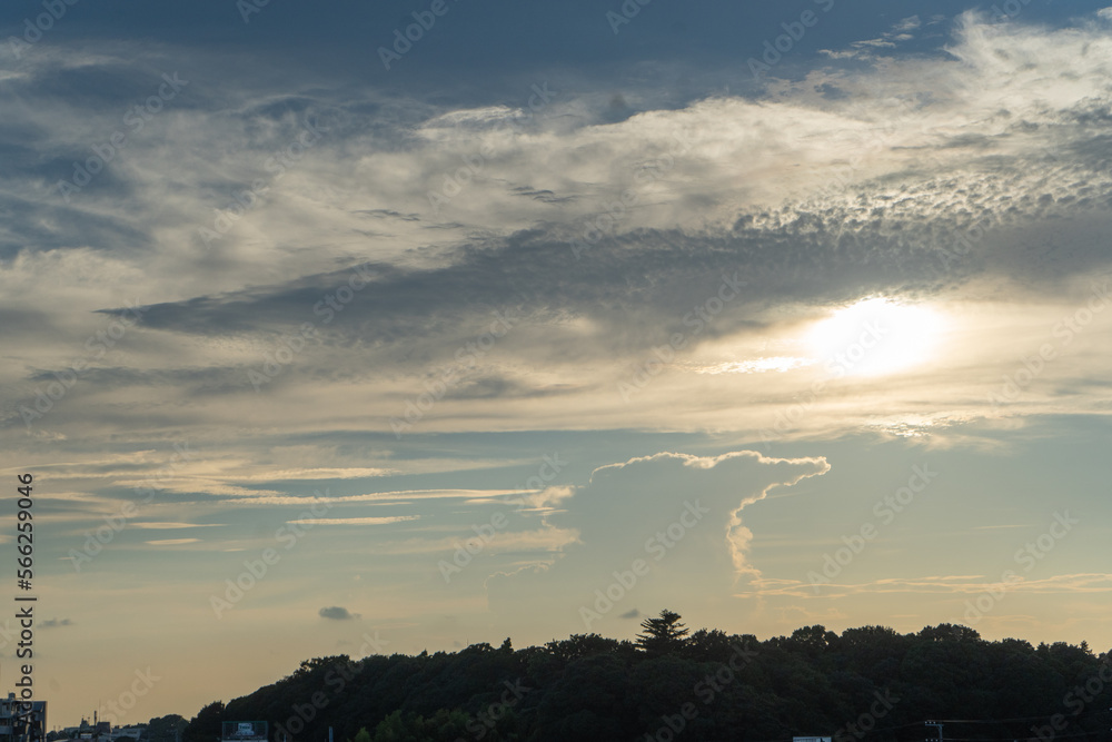 Obraz premium 夏の夕暮れ時、神秘的な太陽を覆う雲