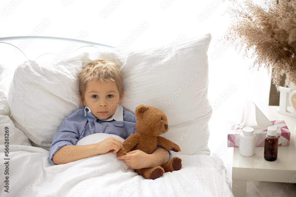 Sweet blond preschool child with teddy bear, lying in bed sick, Sweet blond preschool child with teddy bear, lying in bed sick,