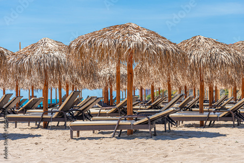 Straw beach umbrellas and sun loungers for relaxing by the sea.