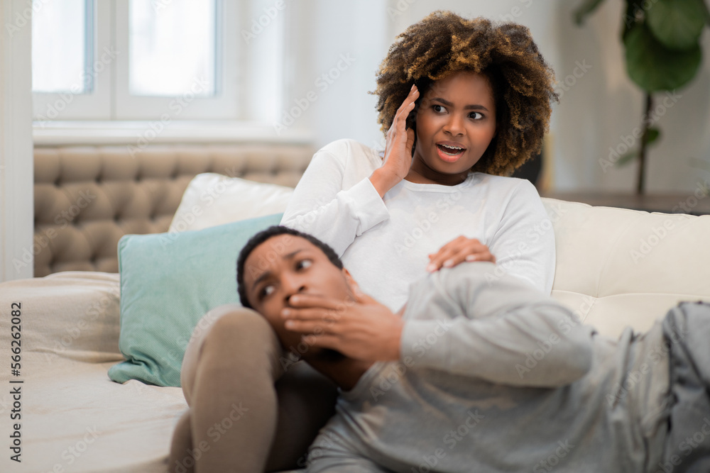 Shocked black couple watching horror at home