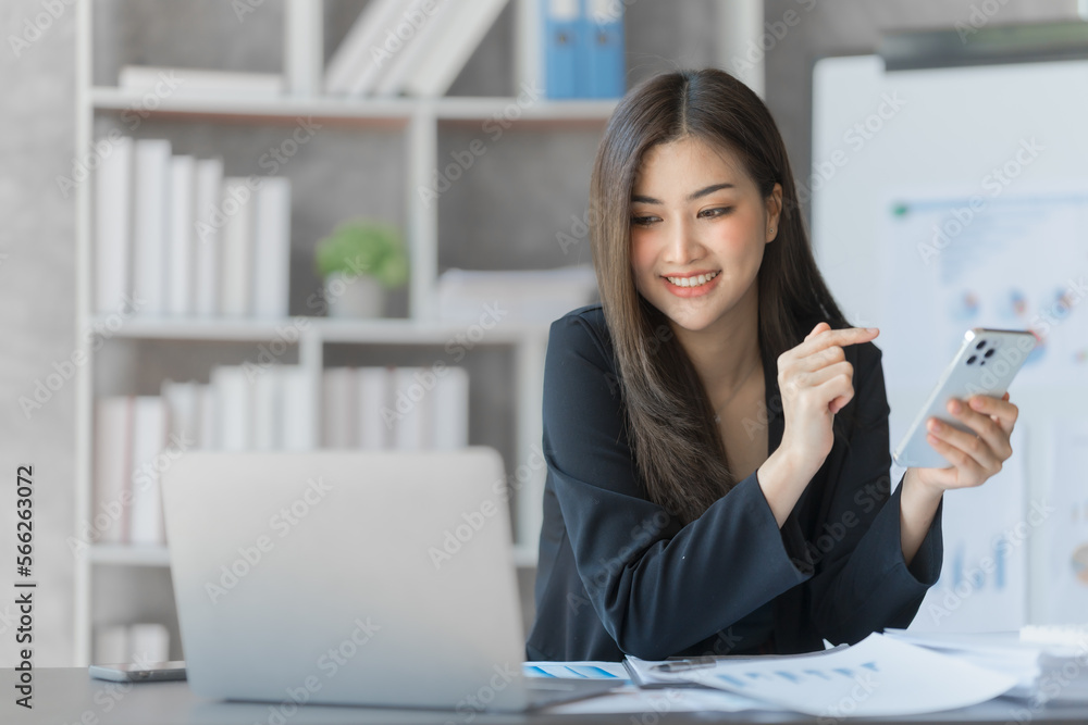 Beautiful Asian female bookkeeper doing online accounting with laptop in private accounting office, balance sheet and stock market statistics. Beautiful Asian female bookkeeper doing online accounting with laptop in private accounting office, balance sheet and stock market statistics.