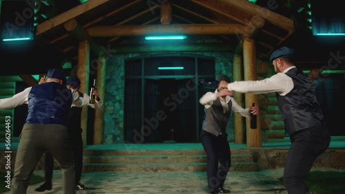 Group of young men dancing synchronized with alcohol drink bottles and glasses . Drunk dancers having fun , celebrating , dancing folk dance on classic outfits . Restaurant or house on background 