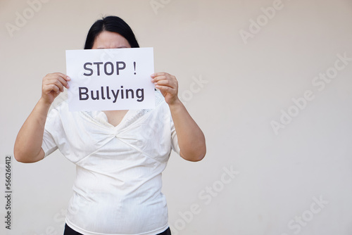Closeup woman holds paper with text " STOP! Bullying" Concept, campaign for anti bullying, body shaming or parody of others physical appearance. Stop violence. 