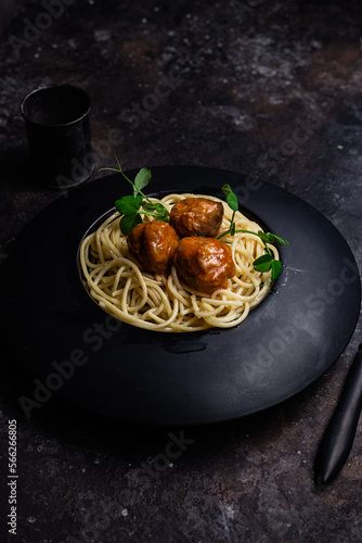 Spaghetti with meatballs in a black plate