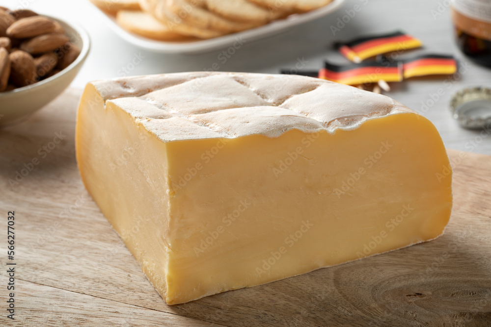 Obraz premium Piece of fresh Brugge Blomme, Belgian cheese, close up on a cutting board