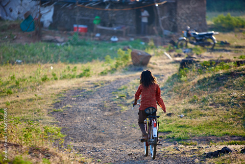 Obraz na płótnie Indian teenage girl is riding an old bicycle at Indian Village w salonie