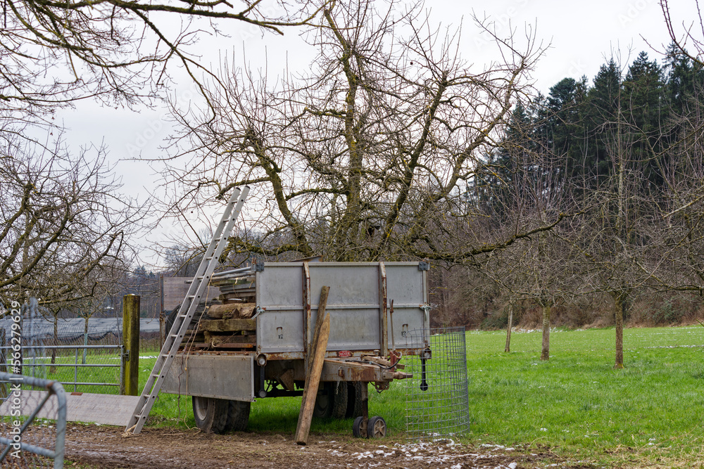 Farm with meadow, trailer and orchard on a gray cloudy winter day at City of Zürich district Schwamendingen. Photo taken January 29th, 2023, Zurich, Switzerland. Farm with meadow, trailer and orchard on a gray cloudy winter day at City of Zürich district Schwamendingen. Photo taken January 29th, 2023, Zurich, Switzerland.