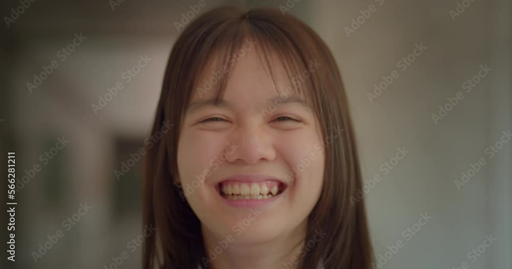 Slow motion scene of a happy smiling and laughing Asian high school student girl. Slow motion scene of a happy smiling and laughing Asian high school student girl.