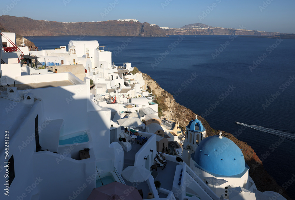  View from viewpoint of Oia village with blue dome of  greek orthodox Christian church and traditional whitewashed greek architecture.  Santorini, Greece
