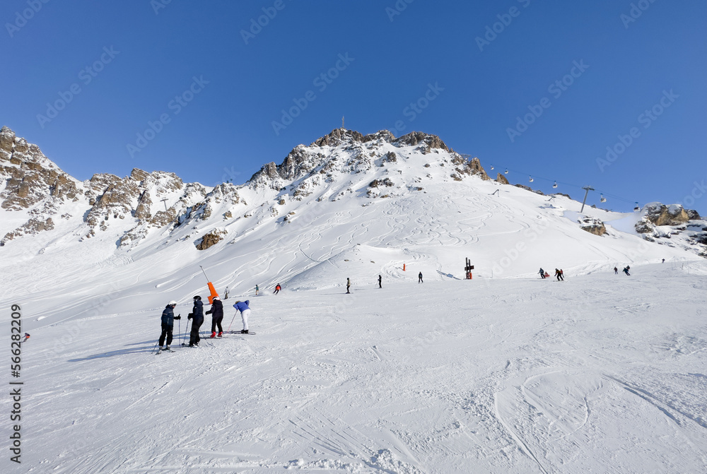 Skiers and snowboarders on the top station of Courchevel and Meribel slopes, France.