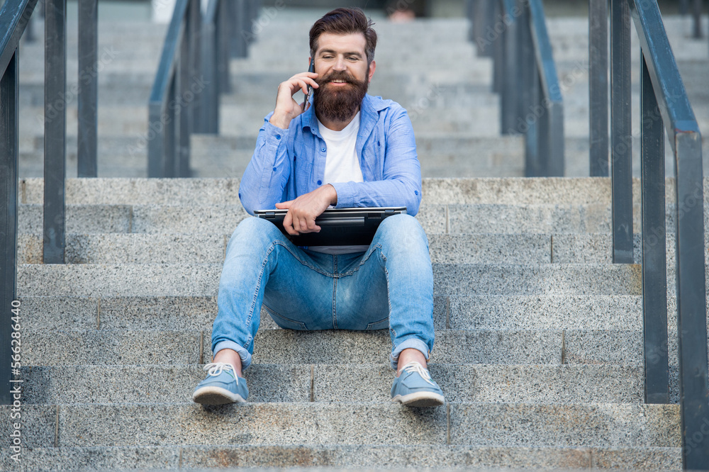 photo of guy talk on smartphone sit on stairs. guy talk on smartphone outdoor. photo of guy talk on smartphone sit on stairs. guy talk on smartphone outdoor.