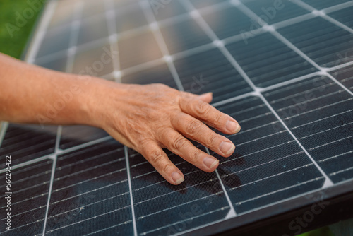 Senior engineer is checking with tablet an operation of sun and cleanliness on field of photovoltaic solar panels on a sunset. Renewable energy, technology, electricity, service concept 