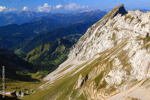 Landscape with a mountain in the foreground and long ranges of mountain ranges in the background against a blue sky with clouds on Mount Pilatus, near Lucerne, Switzerland