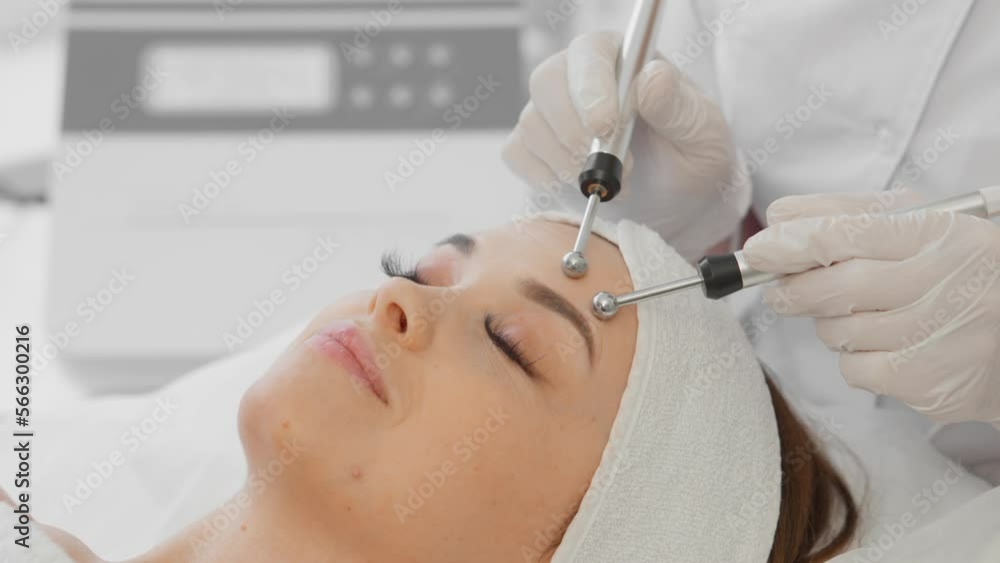 A beautiful woman receives a microcurrent facial skin treatment from cosmetologist in a spa salon. Doctor uses electrical pulses for cosmetic procedures to smooth out wrinkles, restore and rejuvenate A beautiful woman receives a microcurrent facial skin treatment from cosmetologist in a spa salon. Doctor uses electrical pulses for cosmetic procedures to smooth out wrinkles, restore and rejuvenate