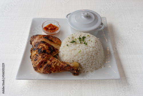 Paris, France - 01 18 2023: African dishe culinary Still Life. Chicken Yassa with Grilled chicken, rice accompaniement and spicy sauce photo