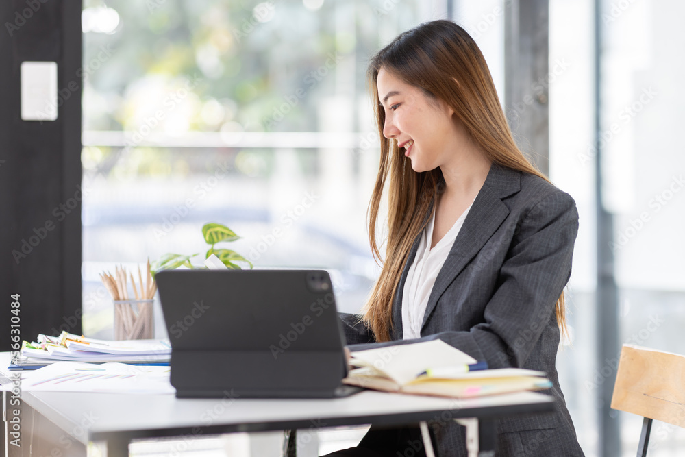 Young business Asian woman is sitting at table, working on laptop with graphs, charts, money and report financial concepts. Online marketing, education, analytics, e-commerce, business planning Young business Asian woman is sitting at table, working on laptop with graphs, charts, money and report financial concepts. Online marketing, education, analytics, e-commerce, business planning