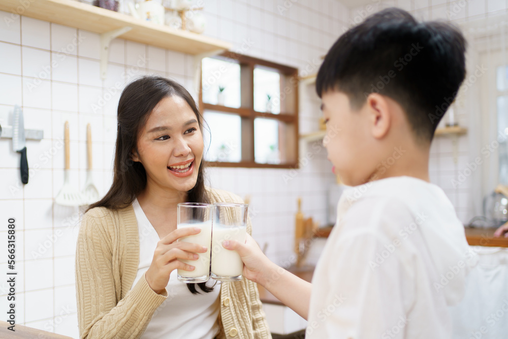 Asian cute little boy having a breakfast with his parent in a kitchen, boy holding a glass of milk and drink. Asian cute little boy having a breakfast with his parent in a kitchen, boy holding a glass of milk and drink.