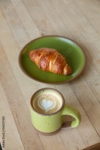 latte and croissant with green dishes