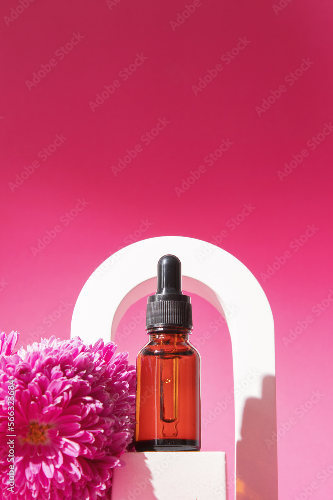 Serum with floral extracts for skincare in arch. Nature cosmetics in glass bottle with pipette and pink flowers on pink background. Face and body care spa concept. Serum with floral extracts for skincare in arch. Nature cosmetics in glass bottle with pipette and pink flowers on pink background. Face and body care spa concept.