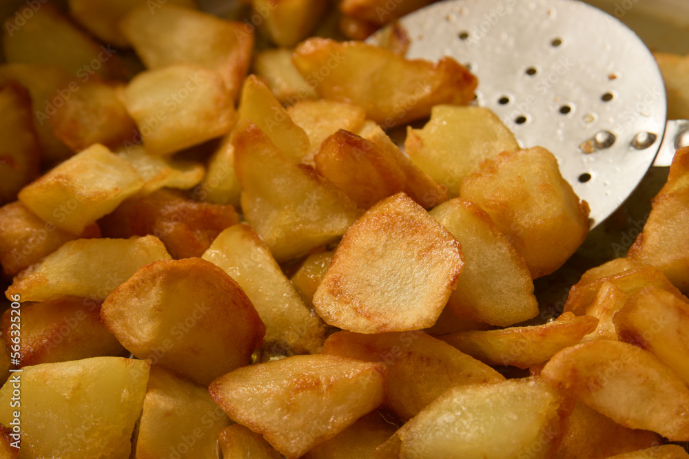 Closeup of some home fries with a metallic spatula to move them Closeup of some home fries with a metallic spatula to move them