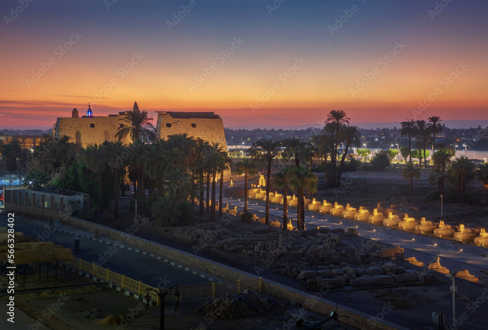 Luxor temple in honor of the god Amun-Ra and the alley of sphinxes after sunset