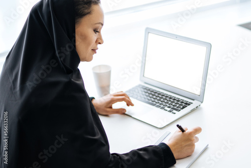 Photography Beautiful woman with abaya dress working on her computer