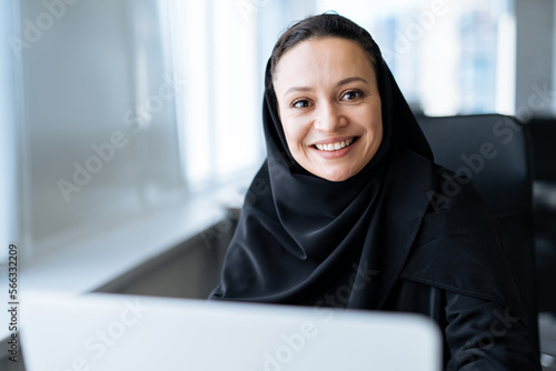 Fototapeta Beautiful woman with abaya dress working on her computer