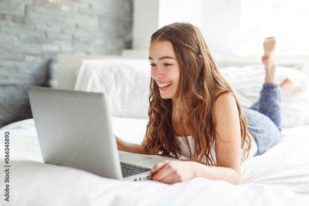 teen with laptop on bed teen with laptop on bed