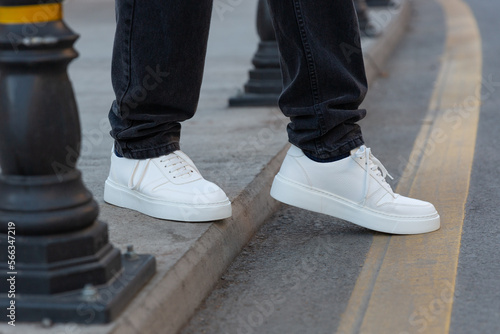 Stylish man in white sneakers shoes on city street © Bitmap