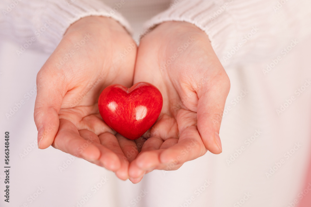closeup hands holding heart on pink background, valentine's day concept closeup hands holding heart on pink background, valentine's day concept