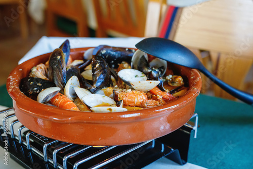 Photos Traditional Spanish seafood zarzuela - stewed fish fillets, sea molluscs and cru