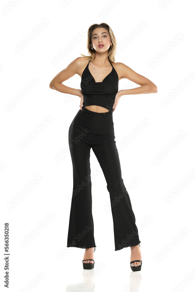 a young woman in black wide trousers and bra posing on a white background a young woman in black wide trousers and bra posing on a white background