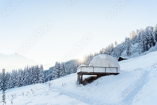 Whitepod winter igloo hotel in swiss mountauns covered by white snow at sunrise at morning. Luxury pods in eco hotel. © Tetiana Soares