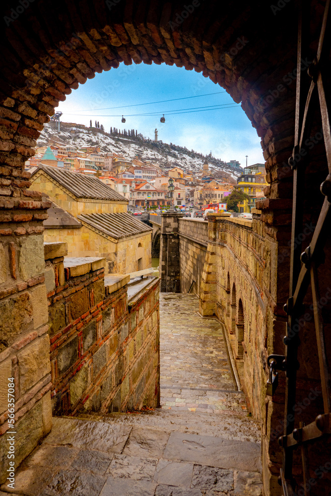 view of city and funicular through archway in tbilisi, georgia