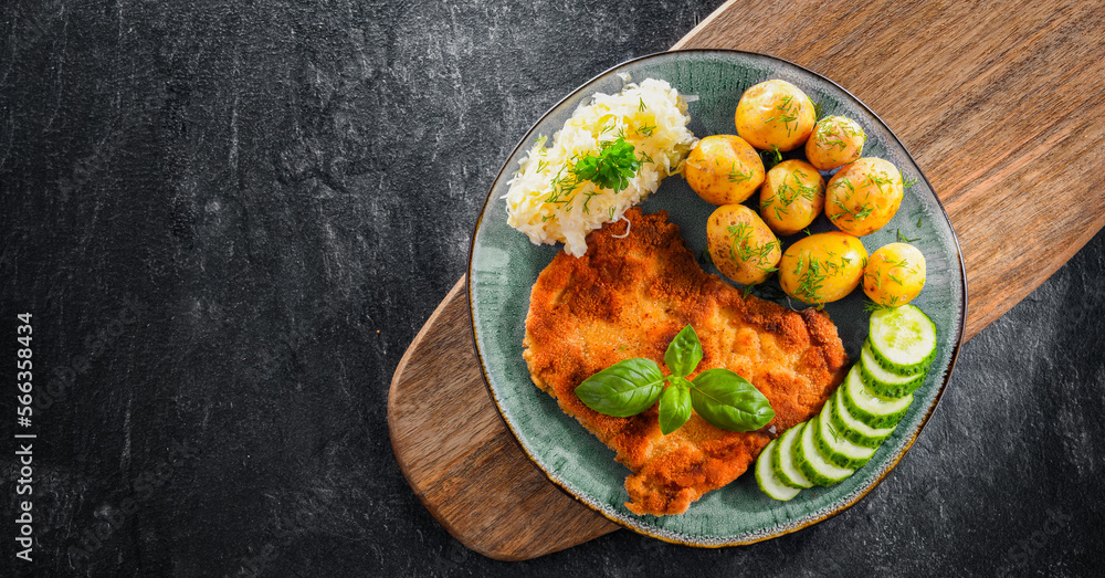 Pork cutlet coated with breadcrumbs with potatoes and cabbage - obrazy, fototapety, plakaty 
