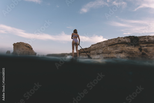 Low angle view of woman paddling SUP board on sea
