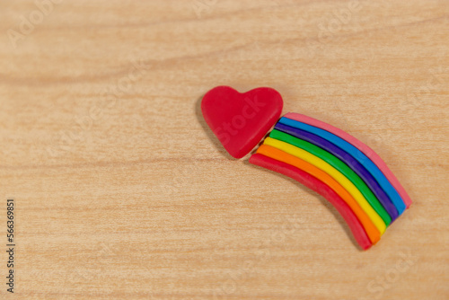  Plastilina en forma de arcoíris (PRIDE) Y corazón en fondo de madera, concepto del día mundial del amor y orgullo LGTBIQ+. 