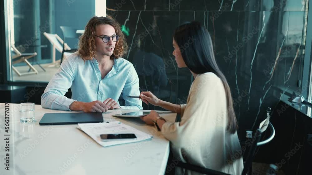 Handsome woman and man managers talking about work while sitting in the office Handsome woman and man managers talking about work while sitting in the office