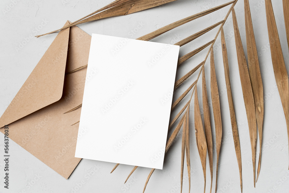 Blank greeting or invitation card mockup with natural palm leaf and envelope, card with copy space Blank greeting or invitation card mockup with natural palm leaf and envelope, card with copy space