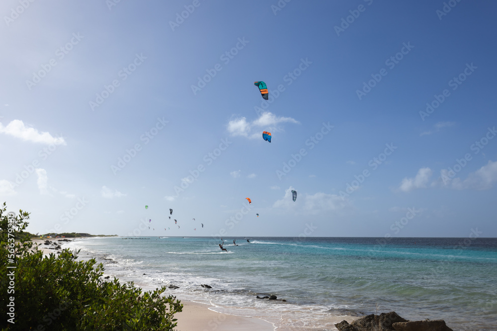 Sandy beach with turquoise water and kitesurfers on the horizon. Kitesurfing lessons. Sandy beach with turquoise water and kitesurfers on the horizon. Kitesurfing lessons.