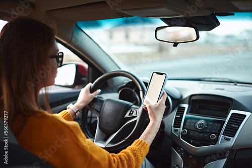 woman driver using mobile phone screen blank mockup on the road while driving a car