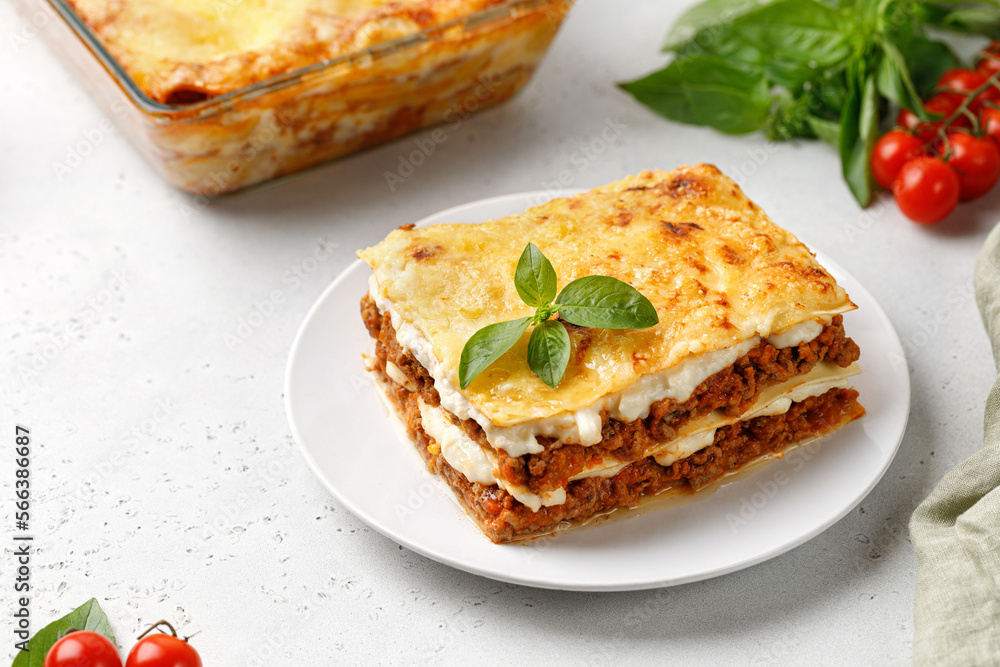 Portion of Homemade Italian lasagna. Delicious Lasagne with bolognese meat sauce and basil on white plate. Hot Tasty Lasagna with cheese. Portion of Homemade Italian lasagna. Delicious Lasagne with bolognese meat sauce and basil on white plate. Hot Tasty Lasagna with cheese.