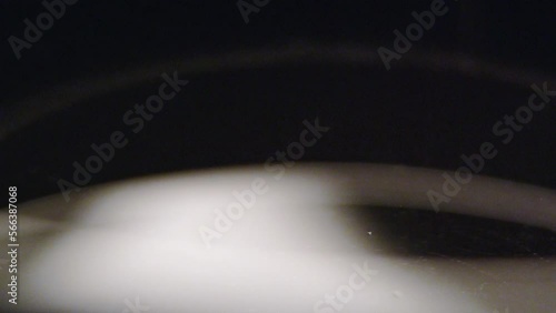 Droplets fall slow from thick flask into clean water and create bunch of ripples. Drops remain in small air bubbles in water macro