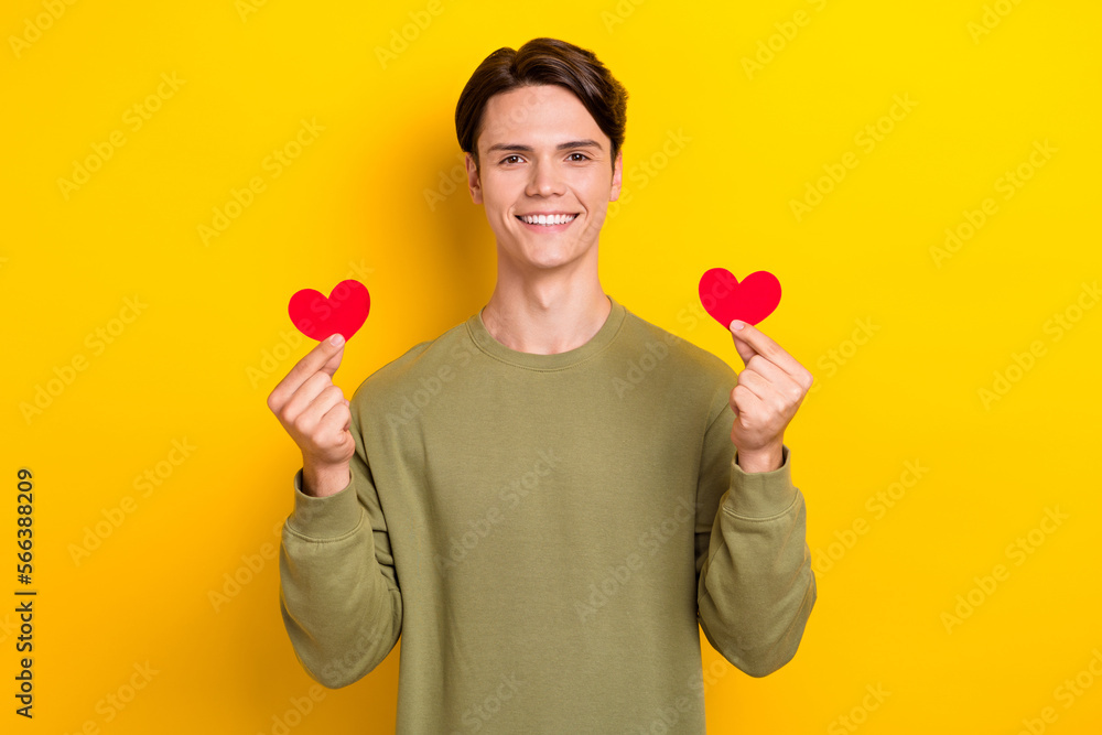 Photo of positive romantic man wear khaki clothes arms demonstrate greetings paper postcards isolated on yellow color background Photo of positive romantic man wear khaki clothes arms demonstrate greetings paper postcards isolated on yellow color background