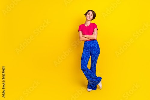 Full length photo of lovely cheerful lady wear stylish bright clothes opening boutique empty space isolated on yellow color background