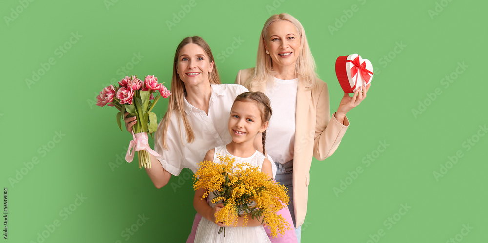 Young woman, her little daughter and mother with gifts on green background. International Women's Day Young woman, her little daughter and mother with gifts on green background. International Women's Day